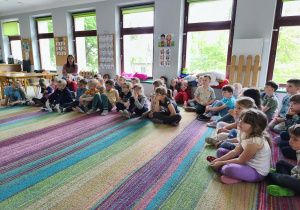 Starszaki siedzą na dywanie i słuchają p. Magdaleny.