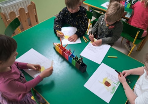 Dzieci kolorują fragment puzzli.