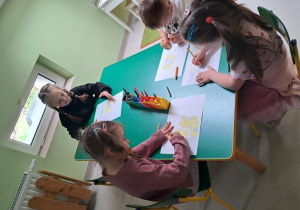 Dzieci kolorują fragment puzzli.