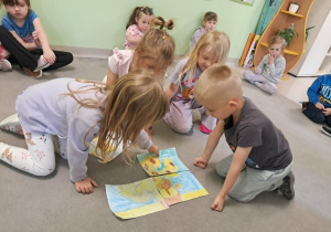 Dzieci prezentują złożone puzzle.