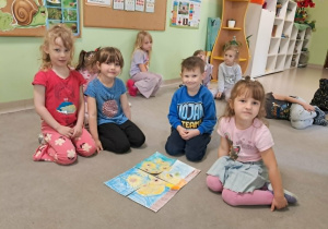 Dzieci prezentują złożone puzzle.