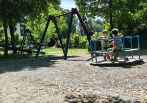 Grupa chłopców spędza czas na konstrukcjach na placu zabaw w Parku Miejskim.