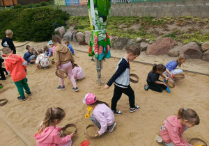 Zabawa w "małego paleontologa" - dzieci szukają i odkopują szkielety dinozaurów.