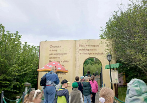 Pani przewodnik zaprasza dzieci na spacer po bajkowej ścieżce.