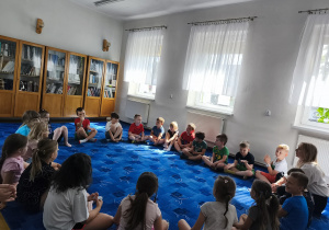 Siedząc na dywanie, rozmawiamy o wakacyjnych planach.