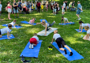 Joga dla dzieci na terenie Parku Miejskiego, prowadzona przez instruktora.