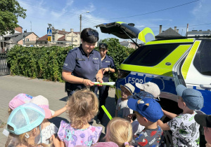 Policjantka rozdaje upominki.