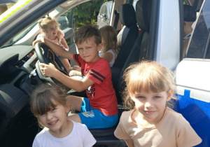 Dzieci oglądają wóz policyjny.