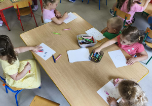 "Pszczółki" dokonując wyboru ulubionej zabawy usiadły do stolików, na których przygotowane były: kredki wraz z kartkami, książeczki, zabawki sensoryczne oraz instrumenty muzyczne.