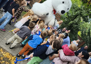 Odwiedziny ogromnego misia podczas pikniku przedszkolnego.