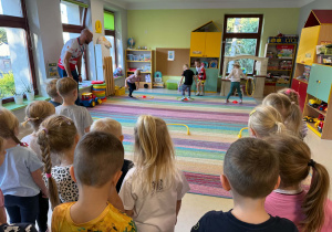 Dzieci biorą udział w zabawach ruchowych proponowanych przez trenera.