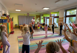 Dzieci biorą udział w zabawach ruchowych proponowanych przez trenera.