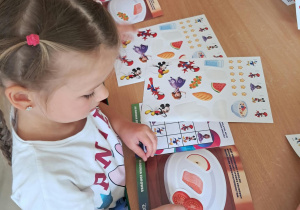 Dzieci tworzą swój zdrowy posiłek z wykorzystaniem naklejek tematycznych.