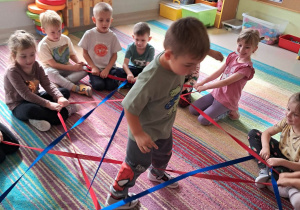"Żabki" uczestniczą w zabawie ruchowej "sieć pająka".