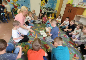 Dzieci z "Wiewiórek" uważnie słuchają nauczycielki ze szkoły
