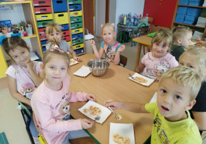 Dzieci jedzą przygotowaną wspólnie sałatkę.